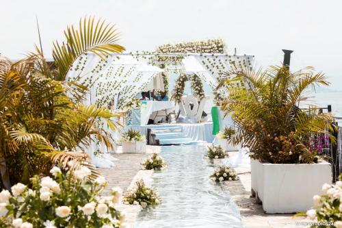 a wedding ceremony in a white room with plants at Cap Kivu Hôtel in Goma