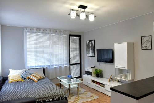 a living room with a couch and a tv at Морски Бриз in Varna City