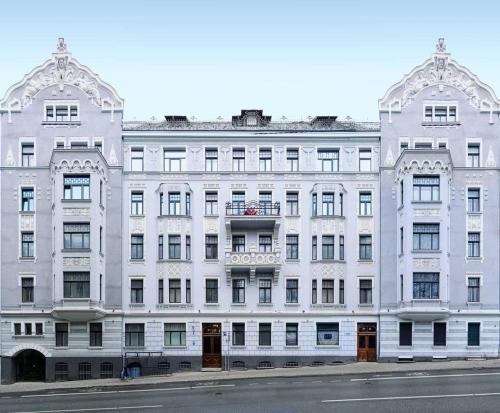 a large white building on the side of a street at Julia Lacplesa Apartments in Rīga