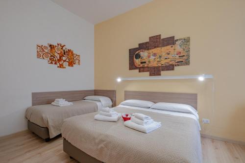 two beds in a hotel room with white towels on them at Damiani & Sister Guesthouse in Rome