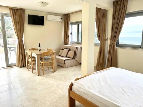 1 dormitorio con cama, mesa y sofá en Villa Blanca en Petrovac na Moru