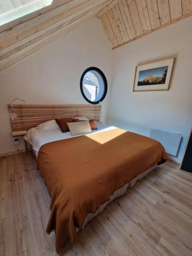 une chambre avec un grand lit avec un miroir dans l'établissement Gîte Laruns 2-4 personnes Le Repaire Montagnard, à Laruns