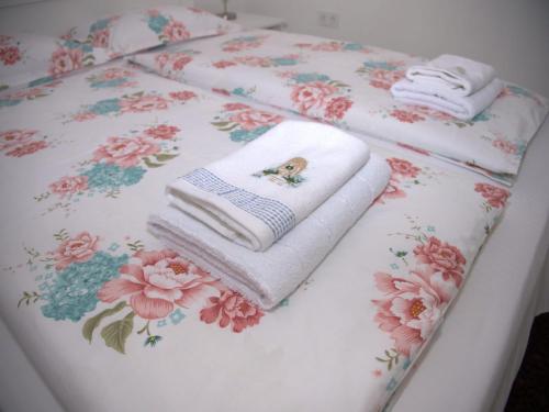 una pila di asciugamani su un tavolo con fiori di Casa Todor a Sibiu