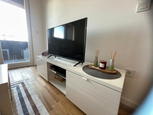 a living room with a flat screen tv on a cabinet at Apartman Nikol in Kumanovo
