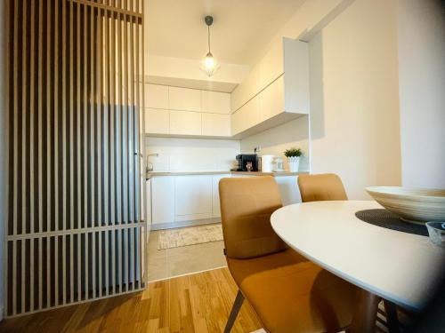 Apartman Nikol في كومانوفو: مطبخ وغرفة طعام مع طاولة وكراسي