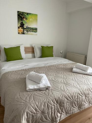 a large bed with two pillows on top of it at Relaxing Bucharest Airport Residences & Therme-SELF CHECK-IN in Otopeni