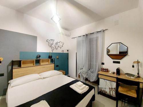 a bedroom with a large bed and a mirror at Don Mario Aparthotel & Rooms in Marina di Camerota