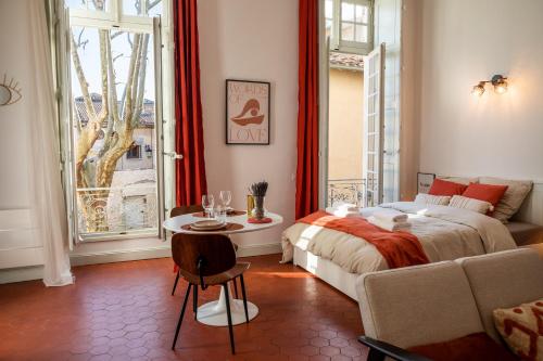 sypialnia z łóżkiem, stołem i oknem w obiekcie Superbe appartement rénové et cosy à 10mn de Saint-Rémy de Provence w mieście Noves