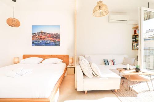 une chambre avec deux lits et un canapé dans l'établissement Le Pythéas - Vue Vieux-Port avec terrasse et clim, à Marseille