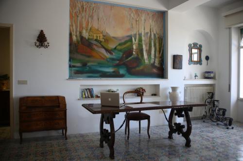 a room with a desk and a painting on the wall at Villa Moschella in Taormina