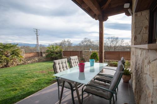 eine Terrasse mit einem Tisch und Stühlen auf einer Veranda in der Unterkunft Casa Rural La Nava de Tizneros in Tizneros