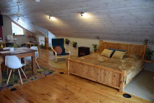 a bedroom with a large bed and a table and chairs at Čučumuiža in Ķimale