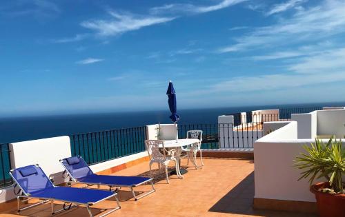 - un balcon avec des chaises et une table donnant sur l'océan dans l'établissement Penthouse with large terrace and roof solarium, with amazing sea views, à Mojácar
