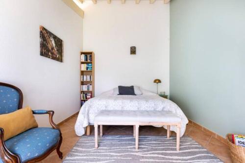 ein Schlafzimmer mit einem Bett und einem blauen Stuhl in der Unterkunft La Chambre Verte in Cazères
