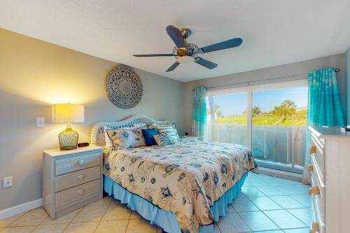 a bedroom with a bed with a ceiling fan and a window at Whitney Beach 149 in Longboat Key