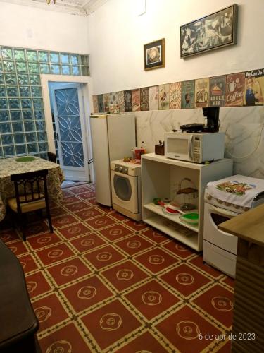- une cuisine avec des appareils blancs et un sol rouge dans l'établissement Estúdios Deluxe São Manuel, à Rio de Janeiro