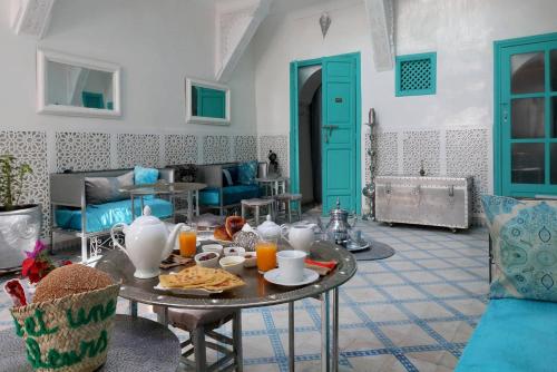 una sala de estar con una mesa con comida y zumo de naranja en Riad 1001 couleurs en Marrakech