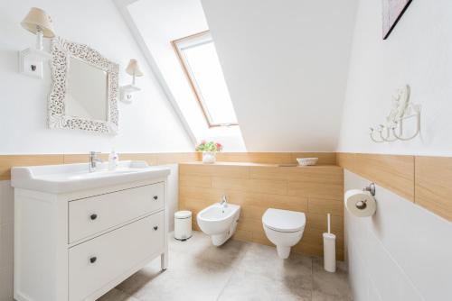 a bathroom with a white sink and a toilet at Villa Mela in Mikołajki