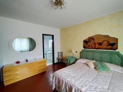 una camera da letto con un letto e un dipinto sul muro di Villa Elba a Praia a Mare