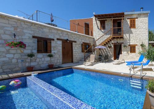 a swimming pool in front of a house at Stonehouse with private swimming pool in Kallepia