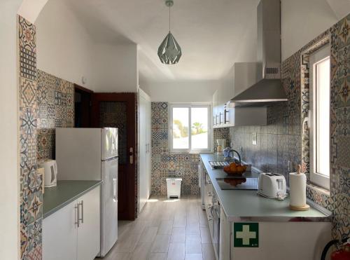 卡武埃魯的住宿－Casa as Gaïvotas，厨房配有白色冰箱,铺有瓷砖地板。