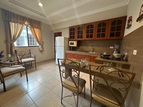 a kitchen with a table and chairs and a refrigerator at El Patio Suites in Guayaquil