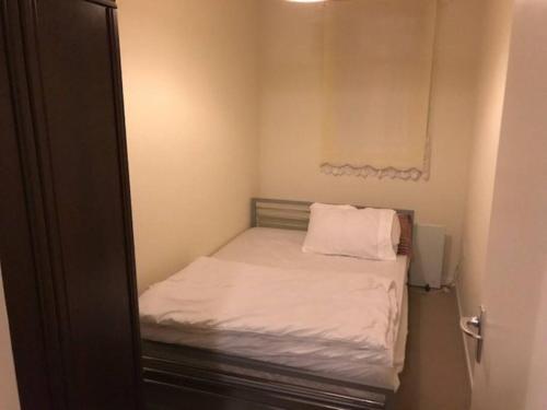 a small bedroom with a small bed with white sheets at 2 bedroom Temsford Close Apartment in Harrow