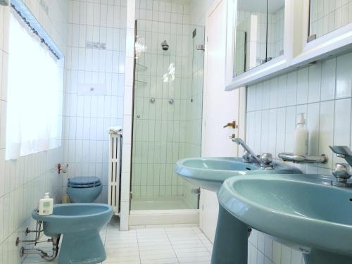 baño con 2 lavabos azules y aseo en Villa Olivia, en Bérgamo