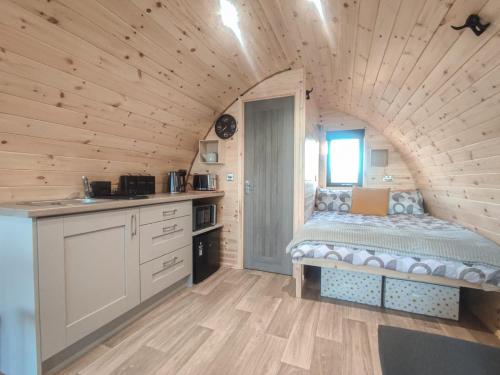 a bedroom with a bed in a wooden house at Haven Pod Easkey in Sligo