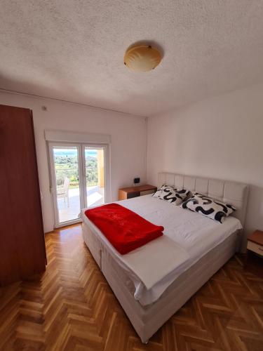 a bedroom with a bed with a red blanket on it at Apartments Niki in Sveti Petar