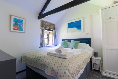 a bedroom with a bed with a towel on it at Cosy cottage in the beautiful Lamorna Valley - walk to the pub & sea in Paul