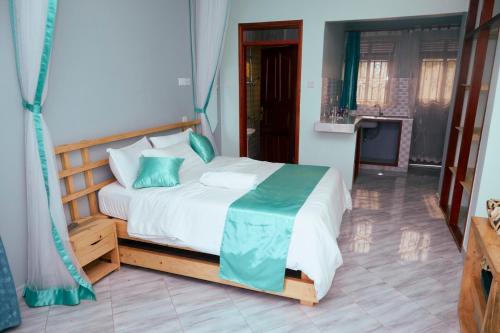 a bedroom with a large bed with blue pillows at WestWay Luxury Suites in Mbarara