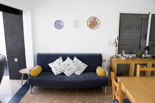 - un canapé bleu avec des oreillers dans le salon dans l'établissement Casa Isaura-Bajamar, à Bajamar