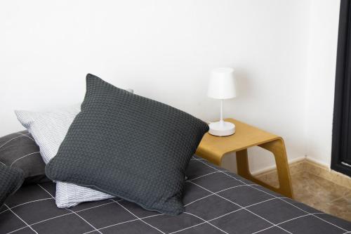 un oreiller assis sur un lit à côté d'une table dans l'établissement Casa Isaura-Bajamar, à Bajamar