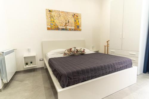 um quarto com uma cama com um quadro na parede em Nena Sweet Home em Palermo