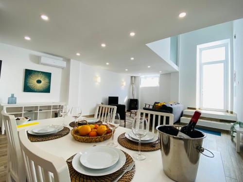a kitchen with a table with plates and wine glasses at Tia Anica House I - apartment with terrace in central Fuseta beach village in Fuzeta