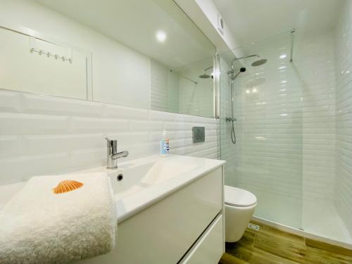 a white bathroom with a sink and a toilet at Tia Anica House I - apartment with terrace in central Fuseta beach village in Fuzeta