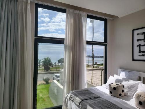 a bedroom with a bed and a large window at 13 at Santos in Mossel Bay