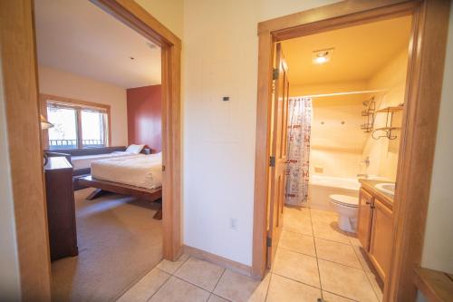 a bedroom with a bed and a bathroom with a toilet at Arapahoe Lodge 8120 in Keystone
