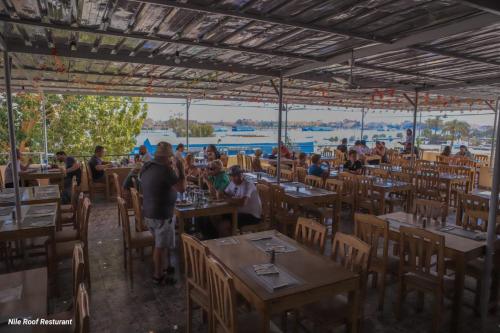 een groep mensen die aan tafel zitten in een restaurant bij Nile Roof Hotel& Restaurant in Luxor