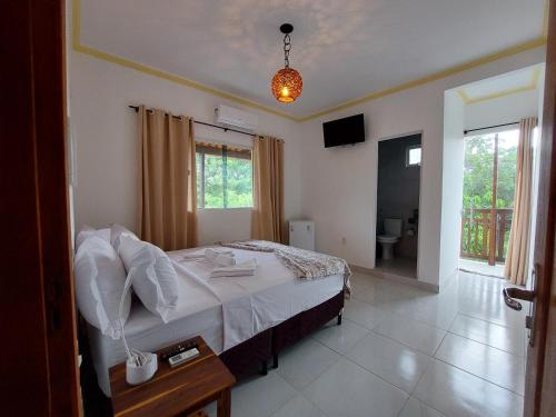 a bedroom with a bed and a room with a television at Pousada Albuquerque in Jijoca de Jericoacoara