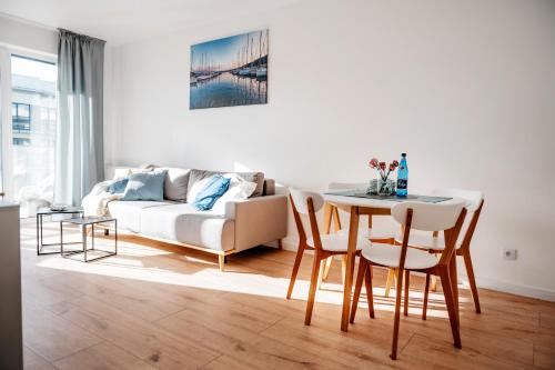a living room with a table and a couch at Golden Port SPA - Easy-Rent Apartments in Dziwnów