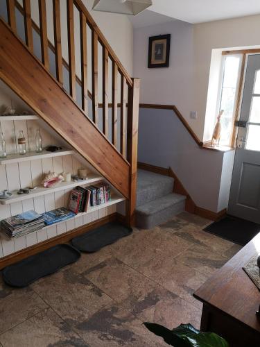 a staircase with a book shelf with books at White Cottage B and B in Spilsby
