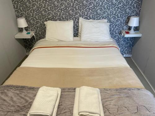 a large bed in a room with two lamps at Liber Guest House in Braga