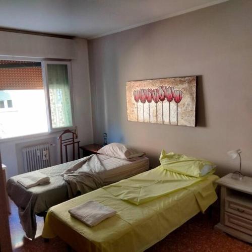 a bedroom with two beds and a painting on the wall at Daniele's flat in Venice Mestre in Mestre