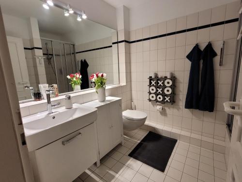 a bathroom with a sink and a toilet and a mirror at Heimathafen Hohwacht in Hohwacht