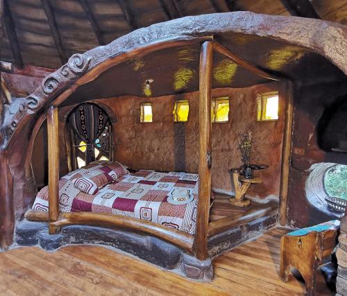 ein Schlafzimmer mit einem Holzbett in einem Zimmer in der Unterkunft La Choza - Casa Suaya La Esperanza in Ibarra