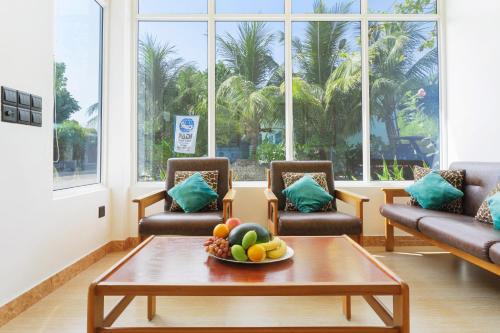 ein Wohnzimmer mit Sofas und einer Schale Obst auf dem Tisch in der Unterkunft Sevinex Inn in Feridhoo