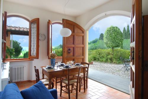a dining room with a table and chairs and a window at Agriturismo Raccianello in San Gimignano
