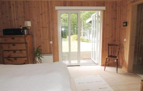 1 dormitorio con 1 cama y puerta corredera de cristal en Holiday Home Vrigstad with Lake View 02, en Vrigstad